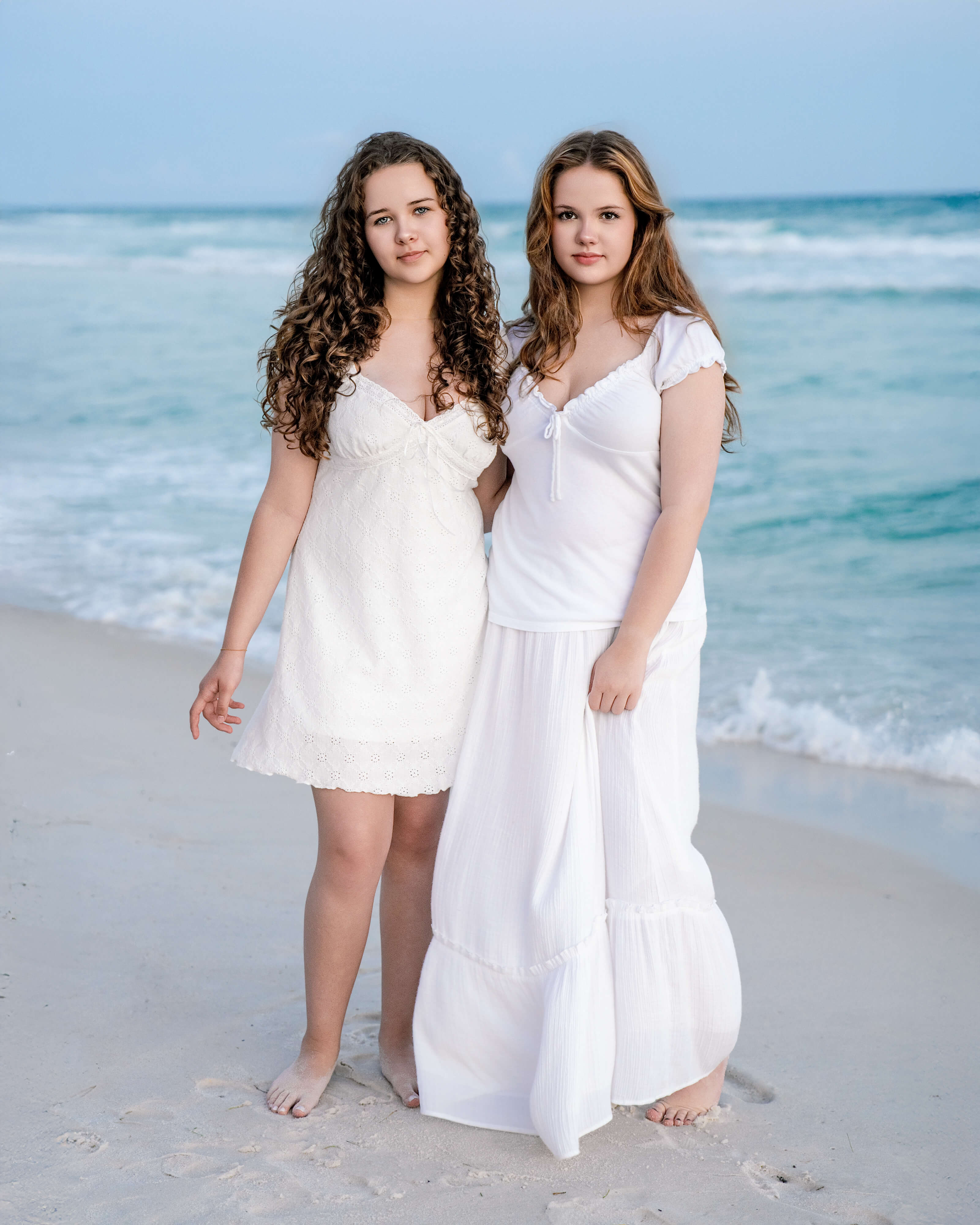 breanne-fine-portraiture-beach-family-child-heirloom-photgrapher-portrait-artist596_1.jpg Two Young teenage sisters pose on the beach of Panama City Beach in Florida at sunset wearing all white wardrobe in classic timeless beach portraits by Breanne Cook of Breanne Fine Portraiture, out of Daphne, Alabama.