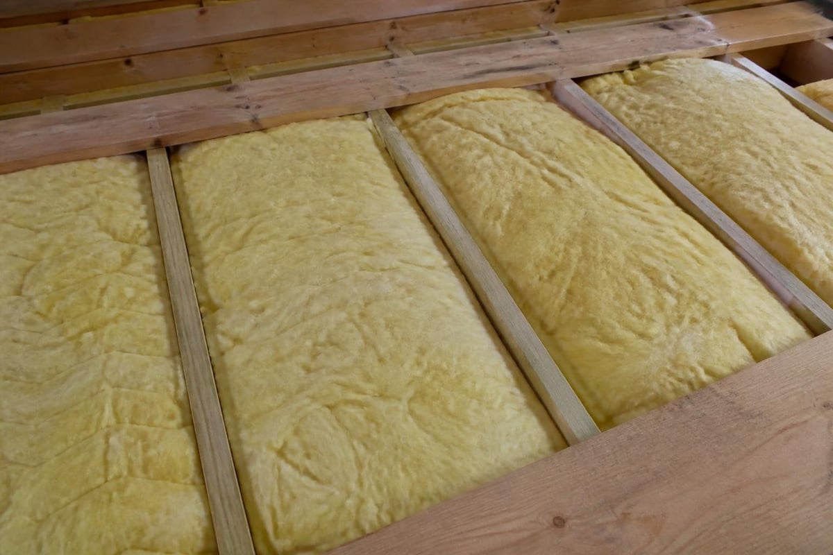 Glasswool batt installation between floor joists