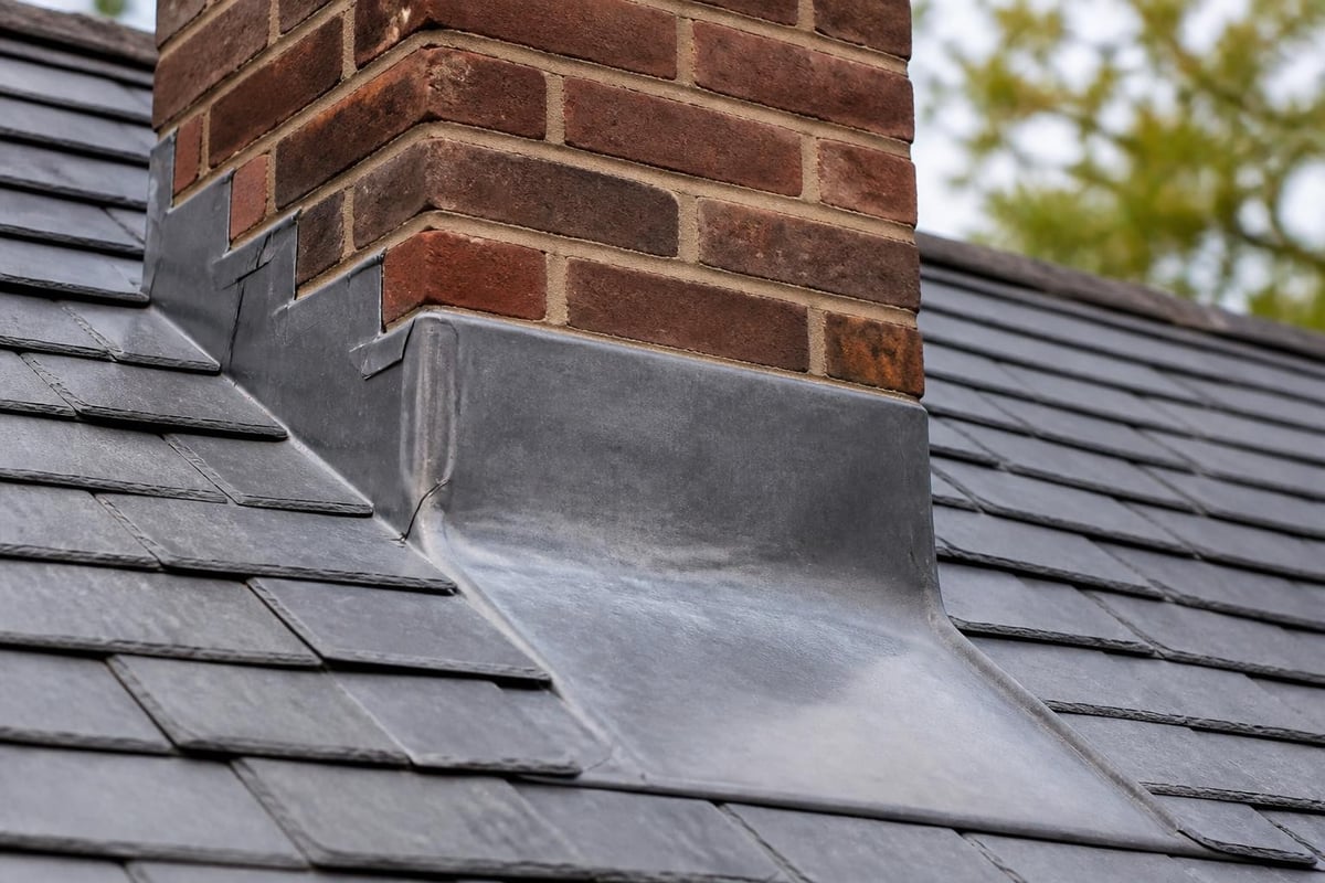 Lead flashing directing water flow at roof transitions